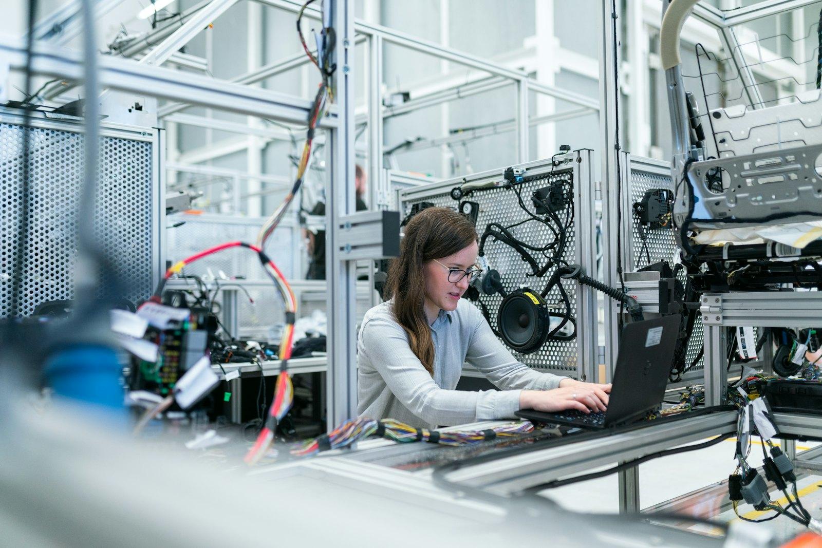 An engineer working at a laptop beside instrumentation in a test facility